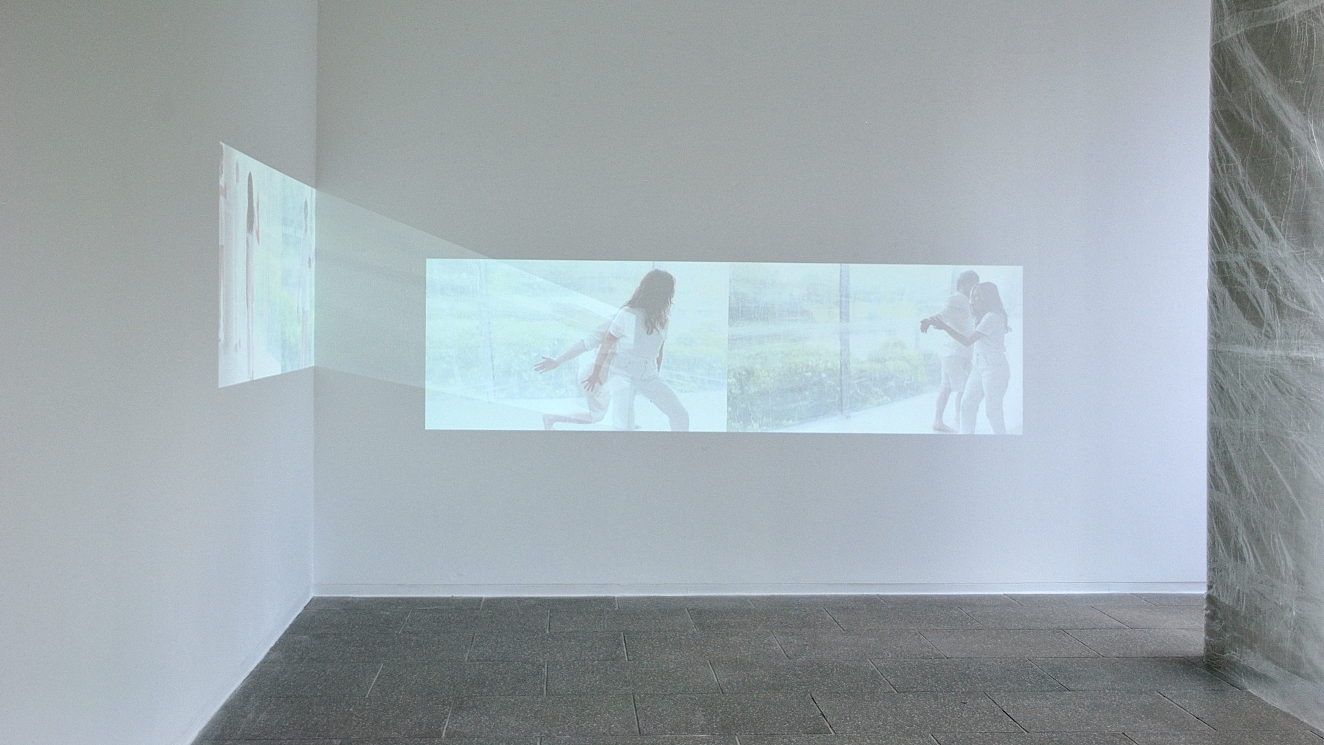 Cos Ahmet, A Meniscus Between, 2021 - Installation view. Two channel digital video projection, 5 mins 2 secs, audio, choreographic object, clear tape. Dimensions variable.